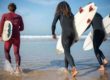 surfeurs courant sur une plage