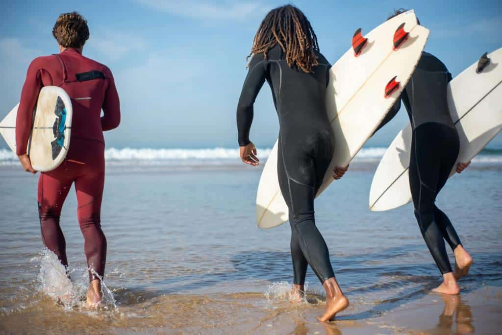 surfeurs courant sur une plage